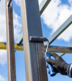 Man painting metal poles. Selective focus. nature.