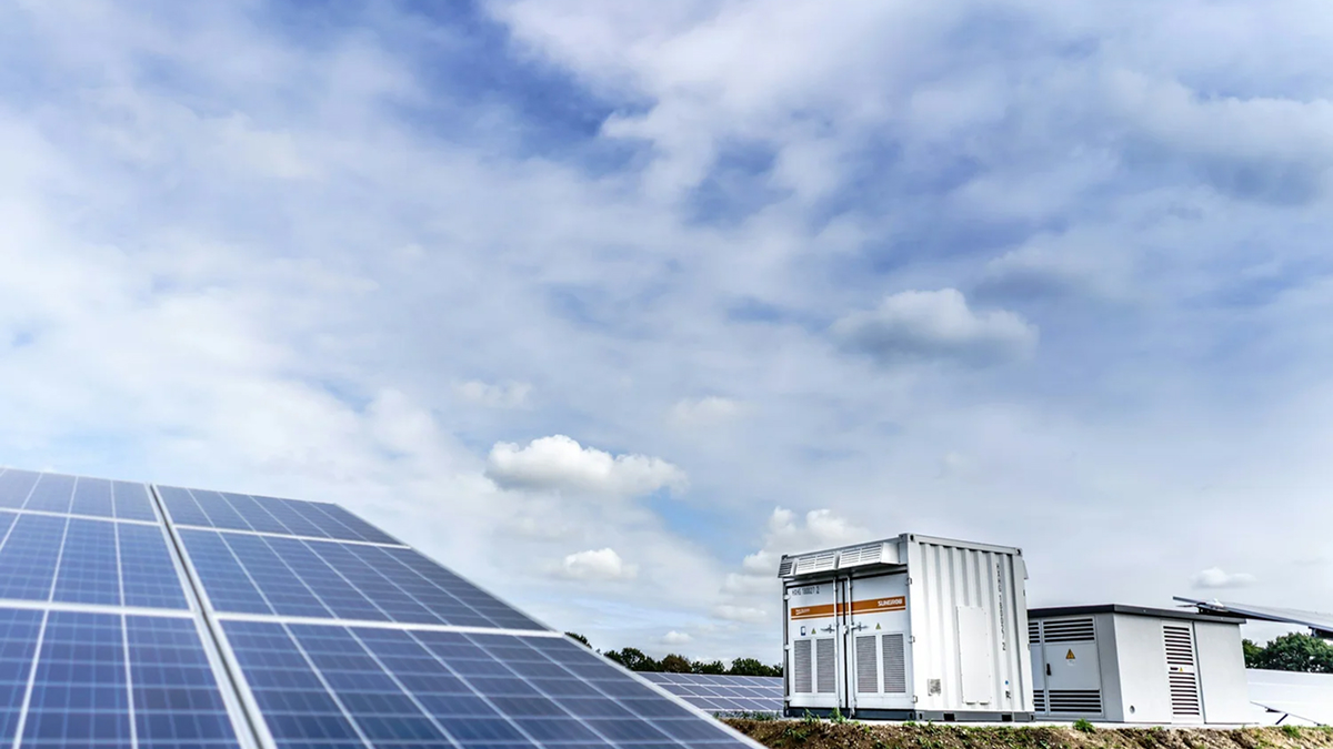 Industrial solar panels and a containerized battery energy storage system protected with NeoCoat Singapore coatings under a cloudy blue sky.